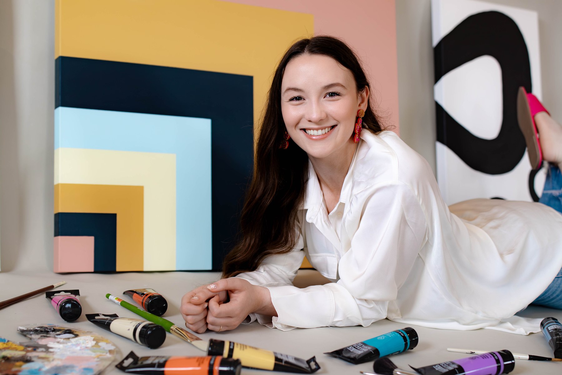 The artist in her studio surrounded by original abstract paintings